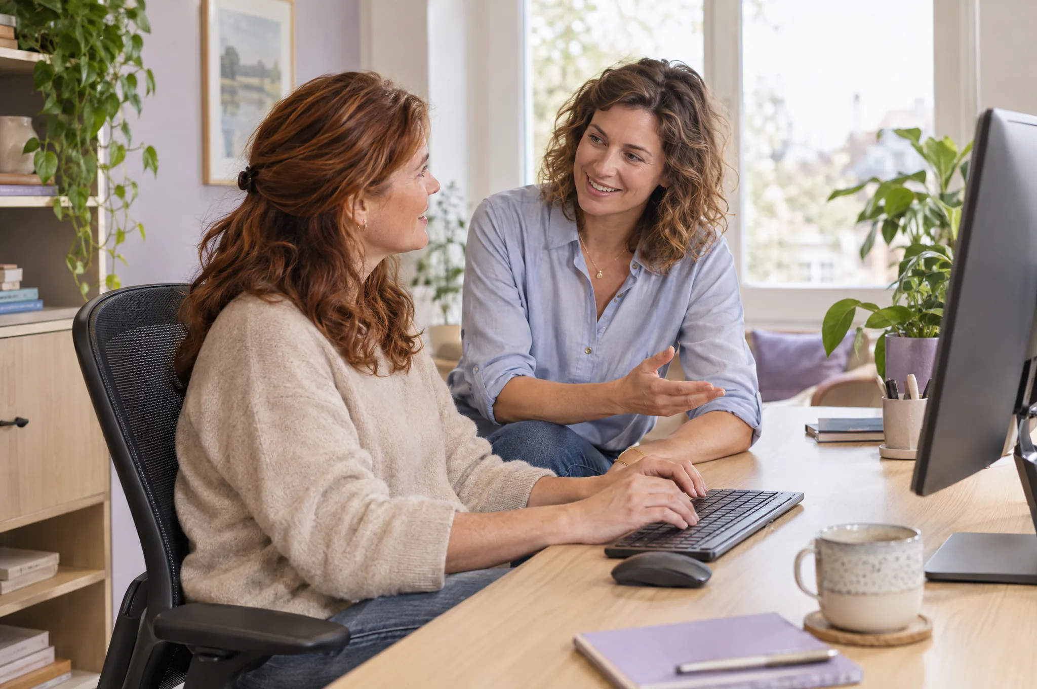 Twee collega’s kijken samen naar een scherm